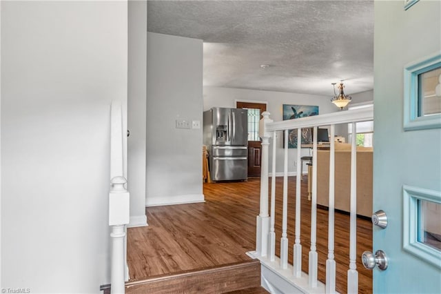 hall with hardwood / wood-style flooring and a textured ceiling