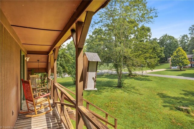 wooden terrace featuring a lawn