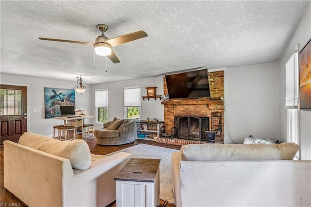 living room with ceiling fan, a fireplace, plenty of natural light, and wood-type flooring