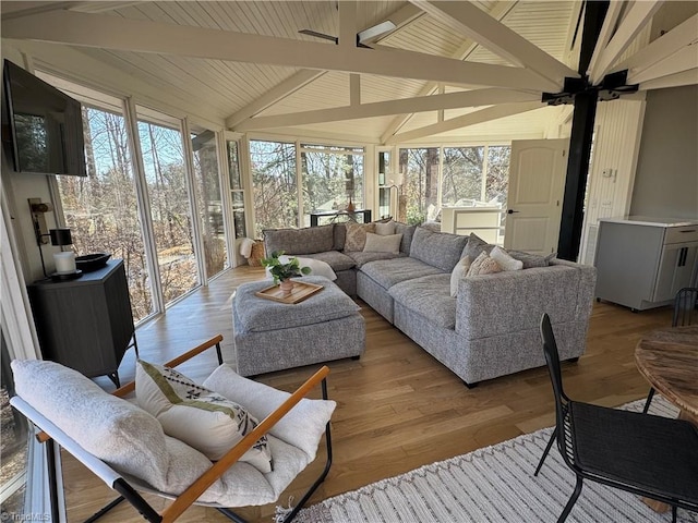 sunroom / solarium with ceiling fan and lofted ceiling with beams