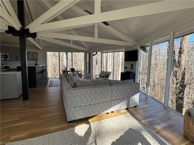 living room with vaulted ceiling with beams, dark hardwood / wood-style flooring, and plenty of natural light