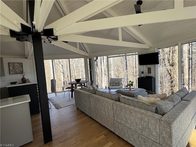 living room featuring plenty of natural light, hardwood / wood-style flooring, and lofted ceiling with beams