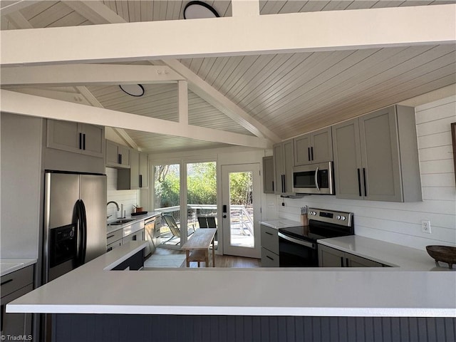 kitchen with appliances with stainless steel finishes, tasteful backsplash, vaulted ceiling with beams, sink, and gray cabinets