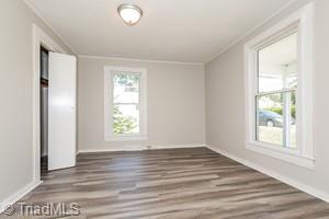 unfurnished room with ornamental molding and hardwood / wood-style flooring