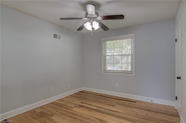 spare room with ceiling fan, light wood finished floors, baseboards, and visible vents