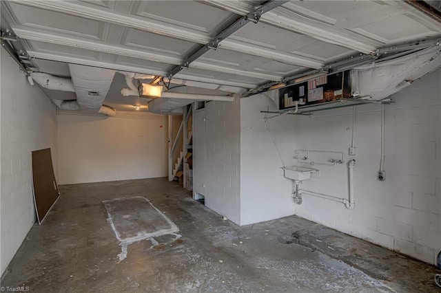 garage featuring a garage door opener and concrete block wall