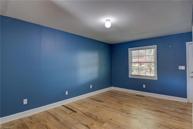 unfurnished room with light wood-type flooring, baseboards, and visible vents
