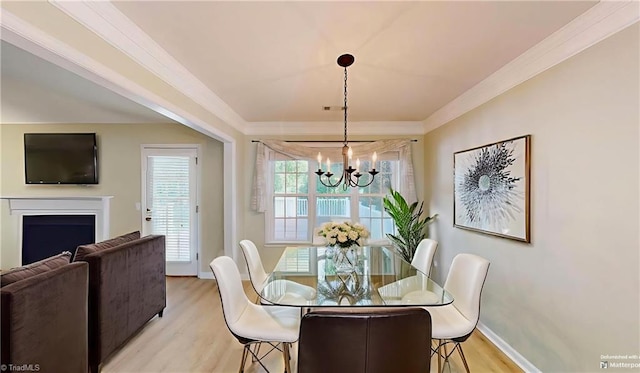 5423 Whitley Way, Greensboro, NC 27407 - dining space with crown molding, a chandelier, light wood-type flooring, and a fireplace