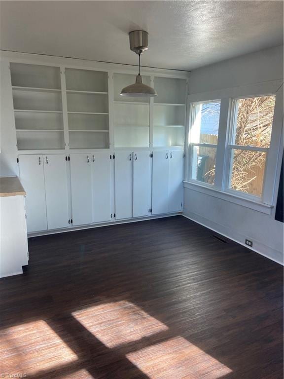 empty room featuring a textured ceiling and dark hardwood / wood-style flooring