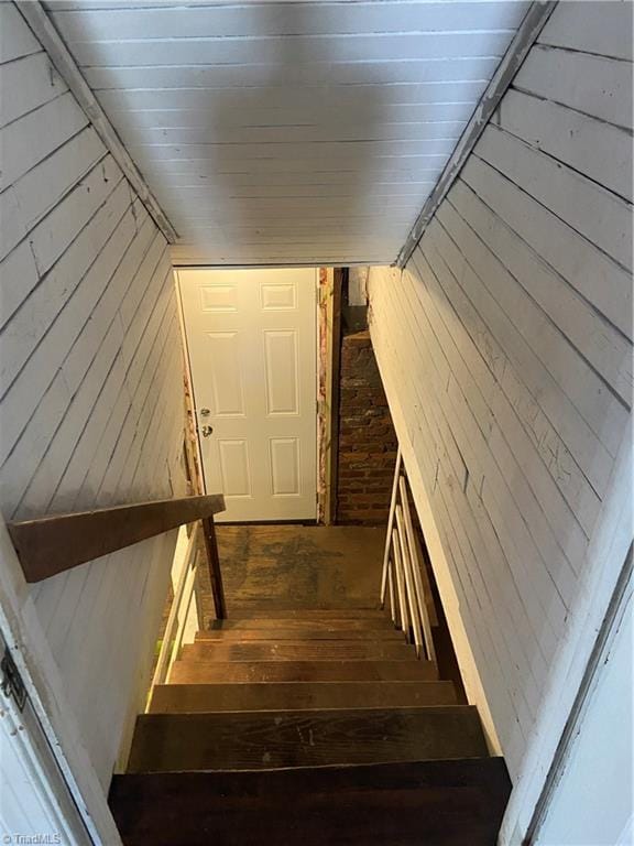 stairway with wood walls and hardwood / wood-style floors