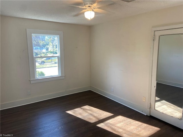 unfurnished room featuring ceiling fan, dark hardwood / wood-style flooring, and a textured ceiling