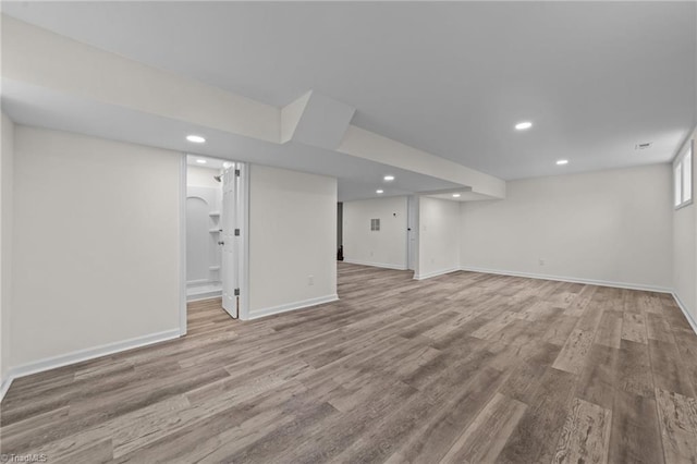 basement with recessed lighting, wood finished floors, and baseboards