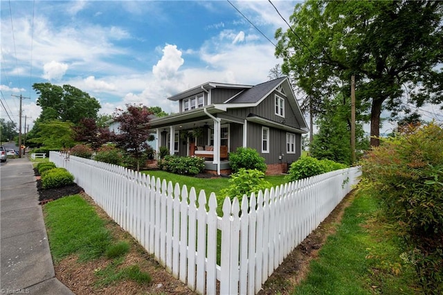 229 Orchard St, Mount Airy, NC 27030 - view of side of property with covered porch, board and batten siding, and a fenced front yard