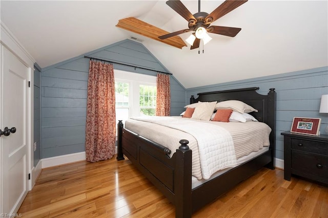 229 Orchard St, Mount Airy, NC 27030 - bedroom featuring light wood-style flooring, vaulted ceiling, wooden walls, a ceiling fan, and baseboards