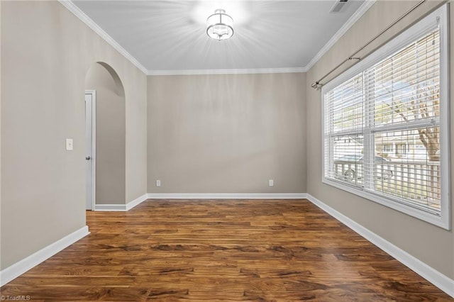 unfurnished room with crown molding, dark wood-style floors, arched walkways, and baseboards