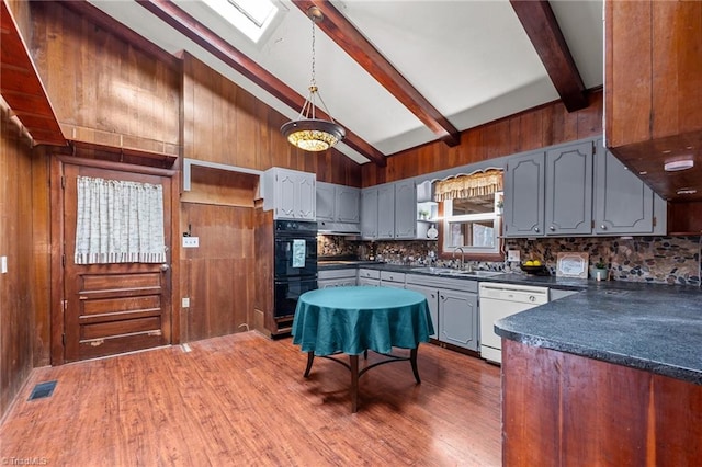 kitchen with dark hardwood / wood-style flooring, vaulted ceiling with skylight, sink, dishwasher, and gray cabinets