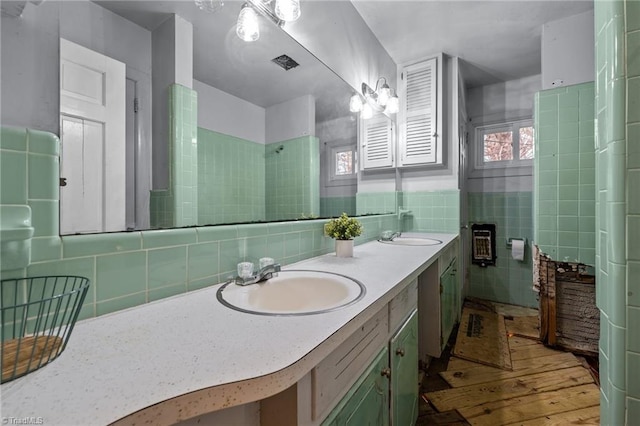 bathroom with hardwood / wood-style floors, vanity, and tile walls