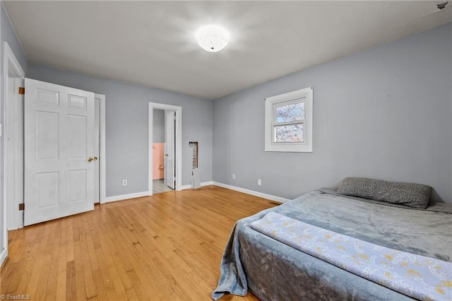 bedroom featuring light wood-type flooring and connected bathroom