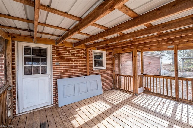 unfurnished sunroom featuring beamed ceiling