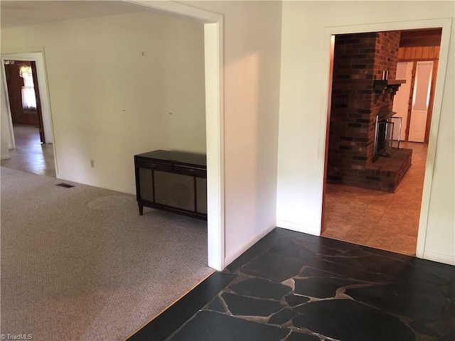 hall featuring dark colored carpet