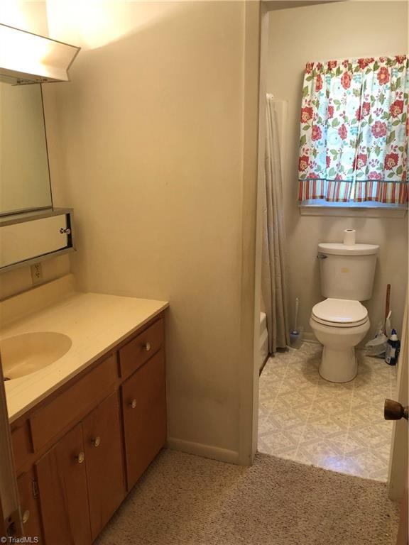 full bathroom with shower / bath combo, vanity, and toilet