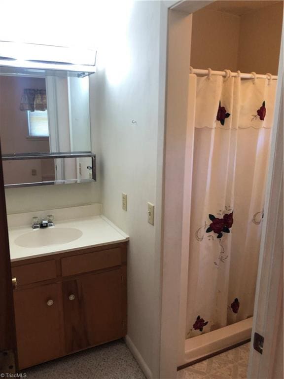 bathroom with walk in shower and vanity