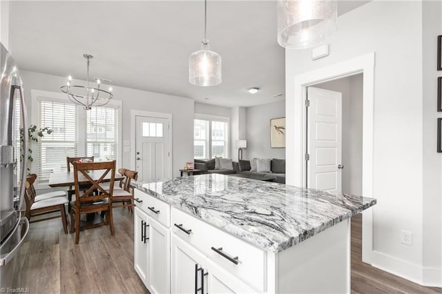 kitchen with white cabinetry, decorative light fixtures, a center island, stainless steel fridge with ice dispenser, and dark hardwood / wood-style flooring