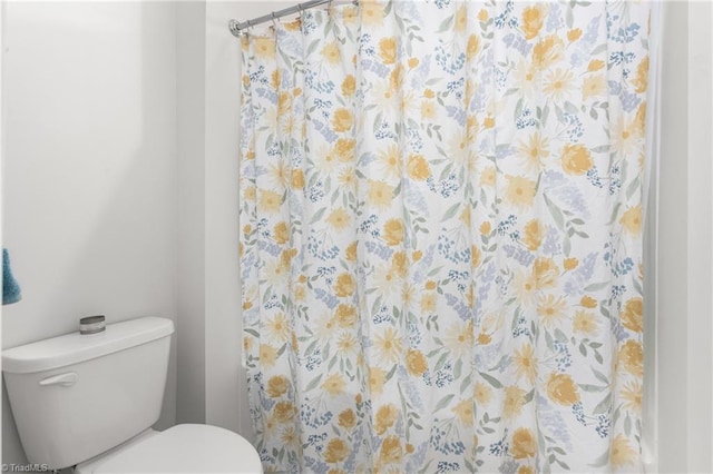 bathroom featuring a shower with curtain and toilet