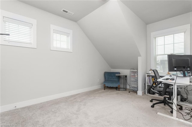 carpeted office space featuring plenty of natural light and vaulted ceiling