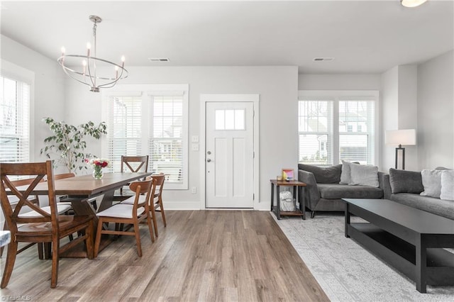 dining area with hardwood / wood-style floors and a notable chandelier