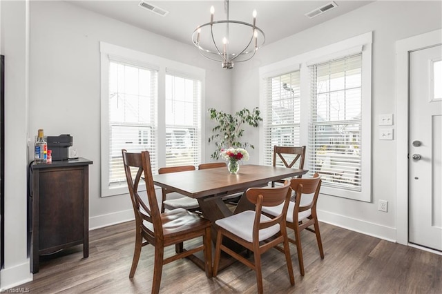 dining space with a chandelier, a wealth of natural light, and dark hardwood / wood-style flooring