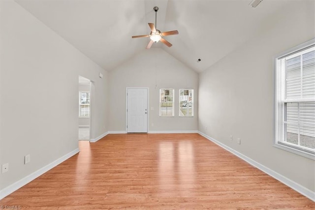 spare room featuring high vaulted ceiling, a ceiling fan, light wood-type flooring, and baseboards