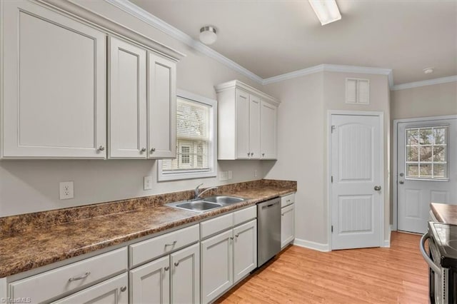 kitchen with a healthy amount of sunlight, ornamental molding, appliances with stainless steel finishes, light wood-style floors, and a sink