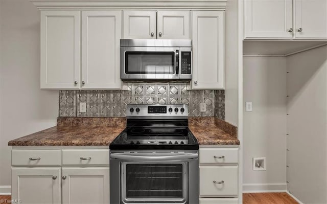 kitchen with white cabinetry, stainless steel appliances, light wood-style floors, decorative backsplash, and baseboards