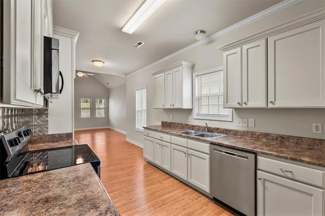 kitchen with a healthy amount of sunlight, crown molding, appliances with stainless steel finishes, a ceiling fan, and a sink