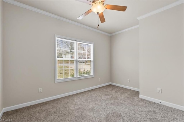 carpeted empty room with ceiling fan, crown molding, and baseboards