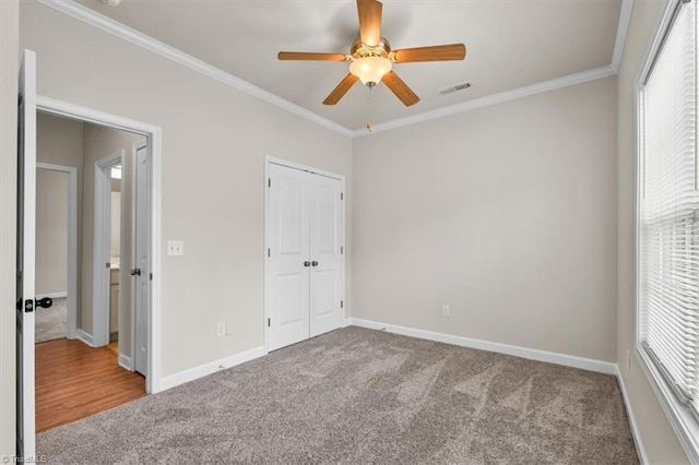 unfurnished bedroom with visible vents, baseboards, carpet, and ornamental molding