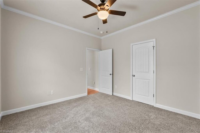 unfurnished bedroom with crown molding, carpet flooring, a ceiling fan, and baseboards