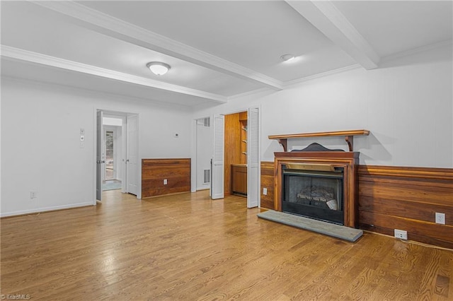 living room with light hardwood / wood-style floors, crown molding, beam ceiling, and wooden walls