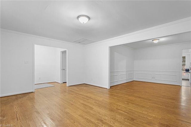 empty room featuring light hardwood / wood-style floors and crown molding