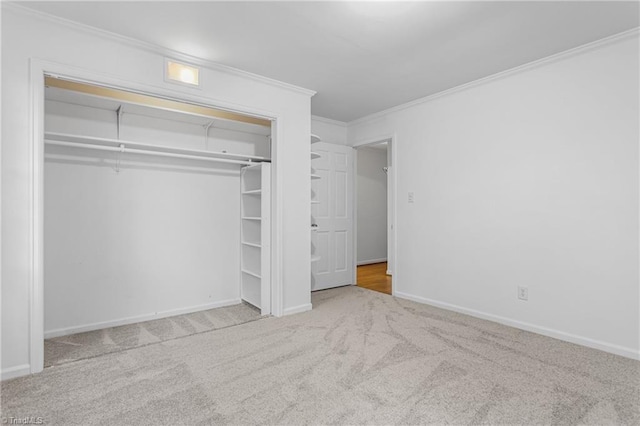 unfurnished bedroom featuring a closet, ornamental molding, and light carpet