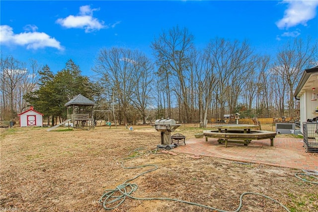 view of yard with a patio area, a playground, and a shed