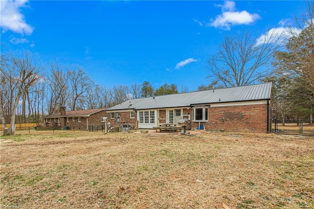 rear view of property with a patio area and a lawn