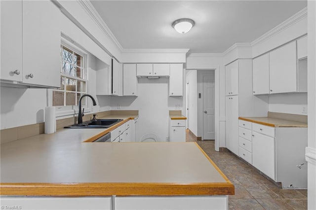 kitchen with white cabinets, kitchen peninsula, crown molding, and sink