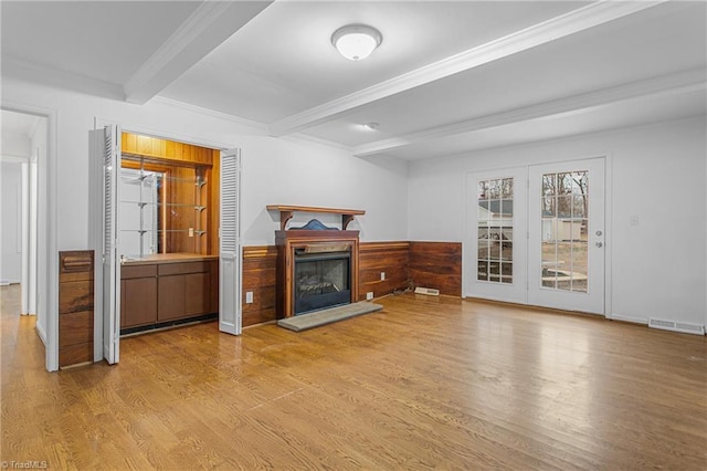 unfurnished living room with light hardwood / wood-style floors, wood walls, and beamed ceiling