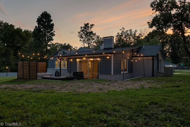 back house at dusk with a lawn