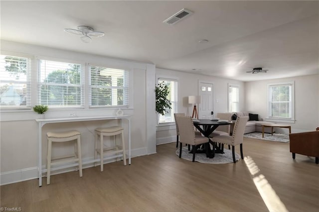 dining space with ceiling fan and hardwood / wood-style flooring