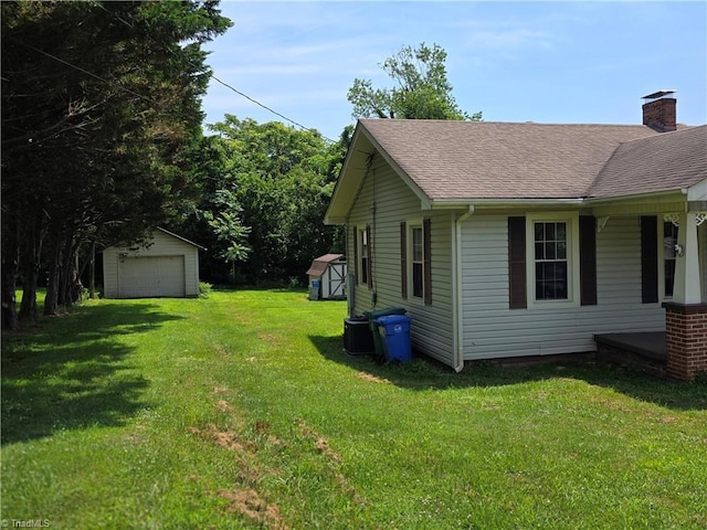 117 Hillcrest St, Jonesville, NC 28642 - view of side of home featuring a garage, a shingled roof, a yard, a chimney, and a shed