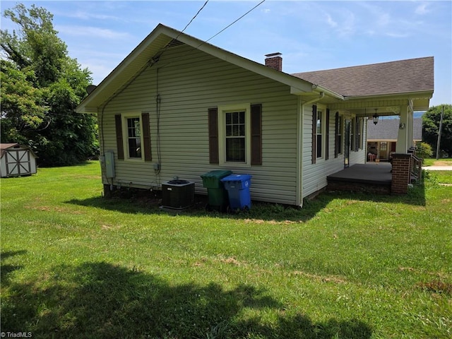 117 Hillcrest St, Jonesville, NC 28642 - back of property featuring a chimney, a shed, a yard, covered porch, and a shingled roof