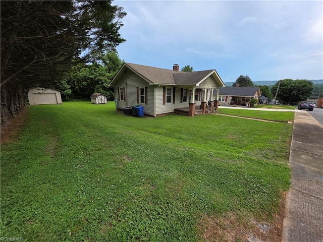 117 Hillcrest St, Jonesville, NC 28642 - view of front of house with a storage unit, a front lawn, a chimney, a detached garage, and driveway